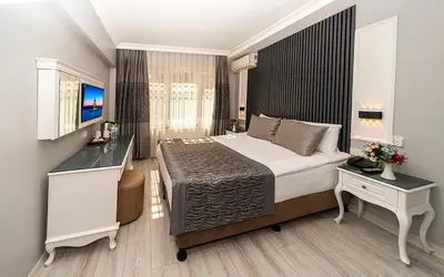 a bedroom with a bed and a desk and a window at Beyazit Palace Hotel in Istanbul