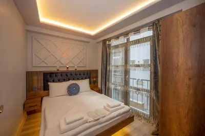 a bedroom with a bed and a large window at Dorne Suite Taksim Hotel in Istanbul