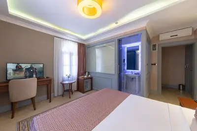 a bedroom with a bed and a desk and a window at No2 Hotel By Şükrü in Adalar
