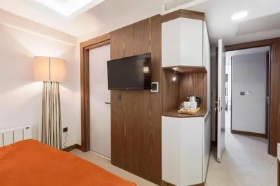a bedroom with a bed and a tv on a wall at Sherry Suites Karaköy in Istanbul