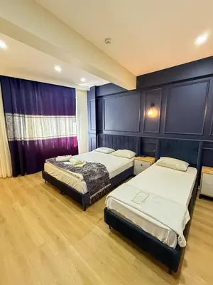 two beds in a bedroom with purple walls and wooden floors at The Reina Hotel in Istanbul
