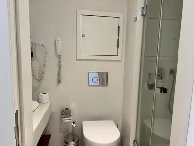 a bathroom with a toilet and a phone on the wall at Akmerkez Residence in Istanbul