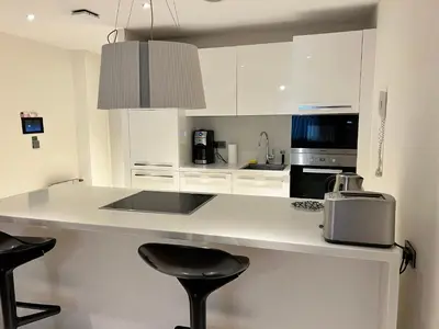 a kitchen with white cabinets and a counter with stools at Akmerkez Residence in Istanbul