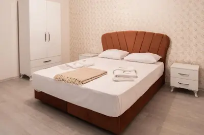 a bedroom with a large bed with a wooden headboard at Araz Suit in Burgaz