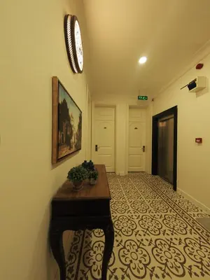 a hallway with a table and a clock on the wall at Nusretbey Hotel in Istanbul