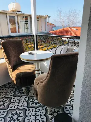 a balcony with a table and chairs on a balcony at Masal Hotel in Buyukada