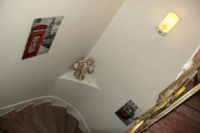 a white staircase with pictures on the wall and a lamp at Masal Hotel in Buyukada