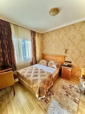a bedroom with a bed and a table and a window at Grand Papirus Hotel in Istanbul