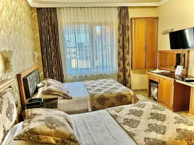 a hotel room with two beds and a television at Grand Papirus Hotel in Istanbul