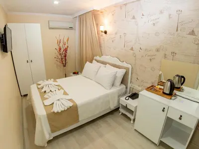 a bedroom with a bed and a desk with a phone at Vander Valk İstanbul Hotel in Istanbul