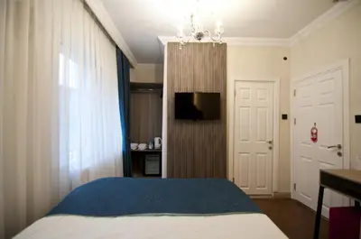 a bedroom with a bed and a tv and a window at Genius Hotel Istanbul in Istanbul