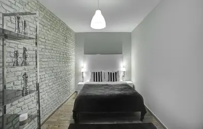 a bedroom with a bed and a brick wall at Beddington Residence Sisli in Istanbul