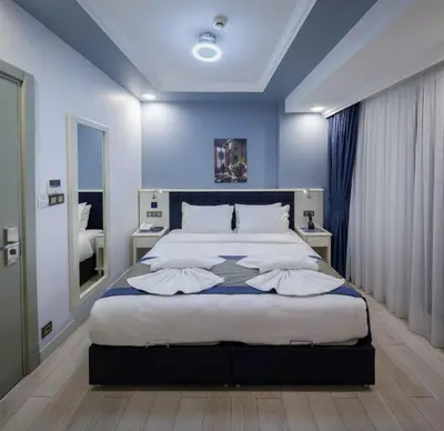 a bedroom with a large bed with blue walls at OBAHAN HOTEL-Special Class in Istanbul