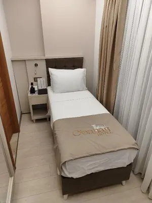 a small bedroom with a bed and a table at OBAHAN HOTEL-Special Class in Istanbul