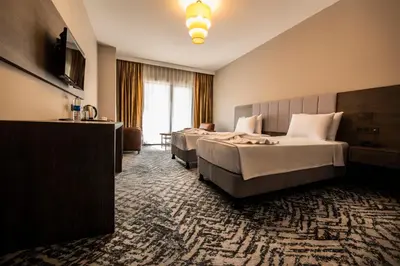 a hotel room with two beds and a large window at Heybeli Garden in Bursa