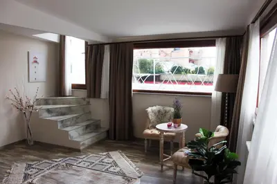 a living room with a staircase and a table and a window at Fuego Design Suites in Istanbul