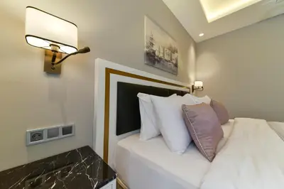 a bedroom with a white bed with a lamp and pillows at Kare Hotel Sultanahmet in Istanbul