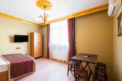 a bedroom with a table and a bed and a table and chairs at The Ottoman Desing Suit in Istanbul