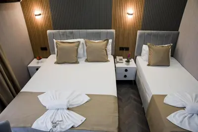 two beds in a hotel room with white sheets and pillows at Grand Bagoz Hotel in Istanbul