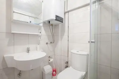 a white bathroom with a toilet and a sink at Sultan Apartments in Istanbul
