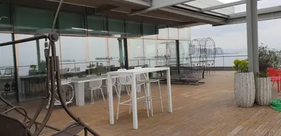 a room with white tables and chairs on a balcony at Ataköy Marina Park Hotel Residence in Istanbul