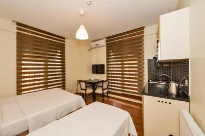 a bedroom with two beds and a kitchen with a table at Invictum Residence in Istanbul