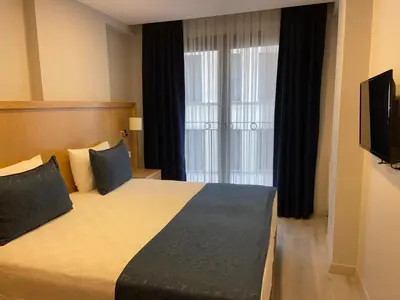 a hotel room with a large bed with a television at Liberi Hotel Taksim in Istanbul