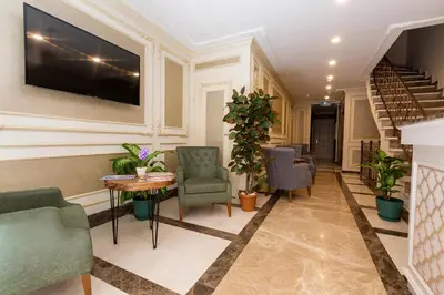 a living room with chairs and a tv on the wall at Villa Sweet Hotel in Istanbul