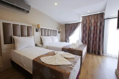 a hotel room with two beds and a window at Villa Sweet Hotel in Istanbul