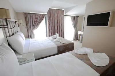 a hotel room with two beds and a television at Villa Sweet Hotel in Istanbul