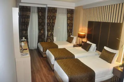a hotel room with three beds in a room at Pell Palace Hotel & SPA in Istanbul