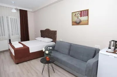 a living room with a couch and a bed at BEKSİTİ HOTEL in Yalova