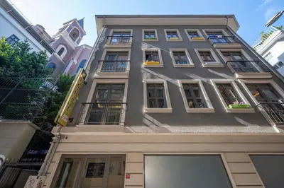 a tall gray building with windows and balconies at Taksim Square Hostel in Istanbul