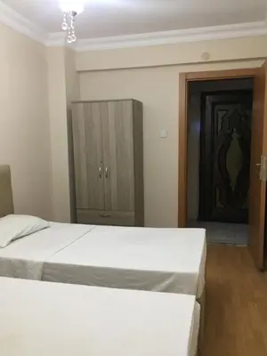 a bedroom with a white bed and a cabinet at Yakup's Apartment in Istanbul