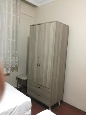a wooden cabinet in the corner of a bedroom at Yakup's Apartment in Istanbul