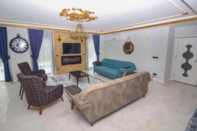 a living room with a couch and chairs and a clock at Bahar Villas Sapanca in Sapanca