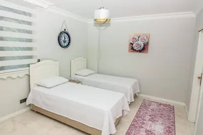 a bedroom with two beds and a clock on the wall at Bahar Villas Sapanca in Sapanca