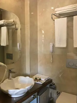 a bathroom with a sink and a toilet and towels at GALATAHAN Hotel Istanbul Karakoy in Istanbul