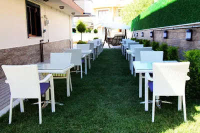 a row of white tables and chairs on the grass at Beach Butik Hotel Şile in Istanbul