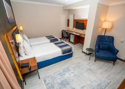 a hotel room with a bed and a chair and a desk at The Bostancı Otel in Istanbul