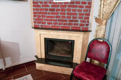 a room with a brick fireplace and a red chair at Ağva Carpediem Otel in Agva