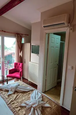 a bedroom with a bed and a pink chair at Ağva Carpediem Otel in Agva