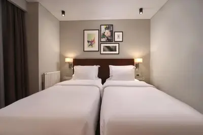 two beds in a hotel room with white sheets at Suadhan Hotel in Istanbul