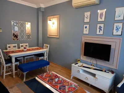 a living room with a television and a table and chairs at Emirhan Guesthouse & Suites in Istanbul