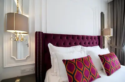 a bedroom with a bed with a purple headboard and two pillows at Blue Mosque Suites 2 - Old City Sultanahmet in Istanbul