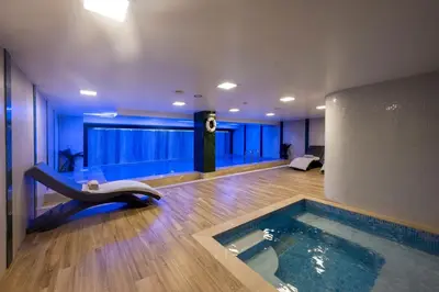 a swimming pool in a room with a tub at Graziella Gold Hotel in Istanbul