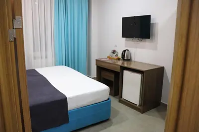 a bedroom with a bed and a desk and a television at İstanbul Terrace Hotel in Istanbul