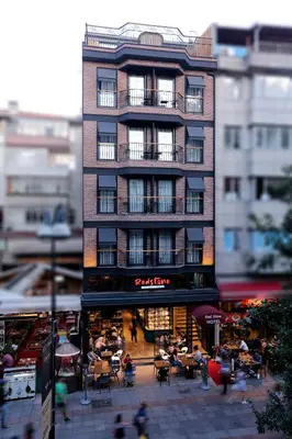 a tall building with people sitting outside of it at Red Stone Hotel in Istanbul