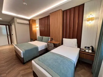 a hotel room with two beds and a table at Gumus Palace Hotel in Istanbul