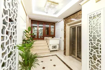 a hallway with white walls and a staircase with plants at City Hall Hotel Sultanahmet in Istanbul